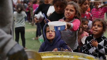 Palestinians lined up for hours for food by a charity kitchen in central Gaza.