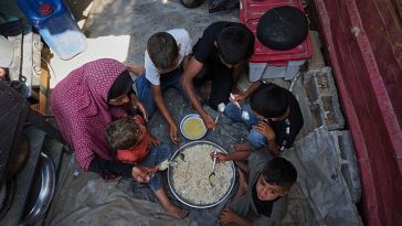 Desperate Palestinians queue for food at soup kitchen during Eid al-Adha
